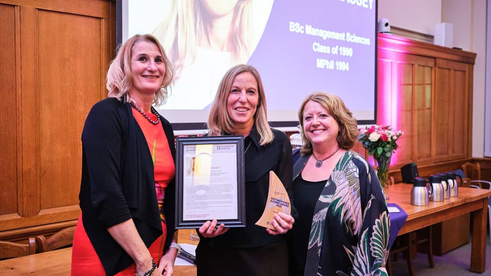 Professor Jan Godsell and Dr Cheryl Travers present a Distinguished Alumni Award to Sarah Massey.